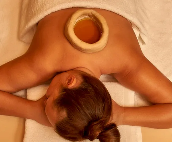 Kadeevasti warm oil pooling therapy on the lower back at 22 Ayur